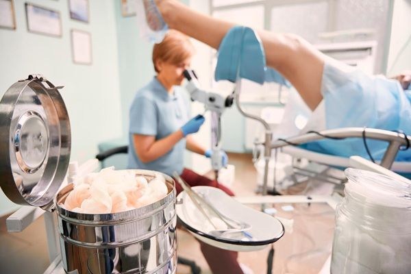 Centro medico Genesi Medico altamente qualificato che esamina una donna con il colposcopio