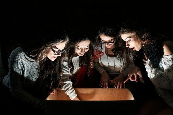 Adolescenti allucinati che esaminano una scatola aperta