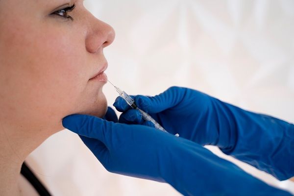 Clinica Biotecnologia Giovane donna che ottiene l'iniezione, vista laterale