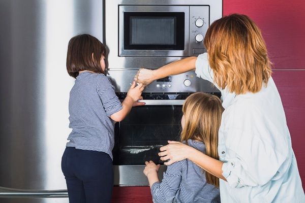 Zappa Elettrodomestici Madre e figli chiudono il forno in cucina