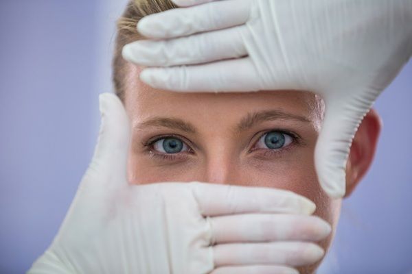 Medico che esamina il viso delle pazienti di sesso femminile per un trattamento cosmetico